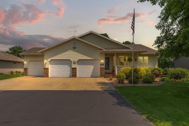 4820 Echo Ct, Faribault, MN 55021 - view of front facade with an attached garage, driveway, a porch, a yard, and brick siding