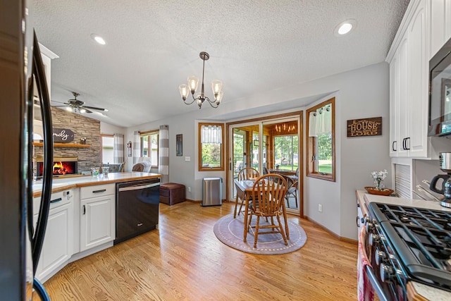 4820 Echo Ct, Faribault, MN 55021 - kitchen with black appliances, a textured ceiling, a fireplace, a ceiling fan, and vaulted ceiling
