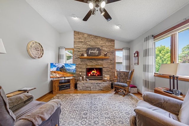4820 Echo Ct, Faribault, MN 55021 - living room featuring a ceiling fan, a fireplace, wood finished floors, plenty of natural light, and a textured ceiling