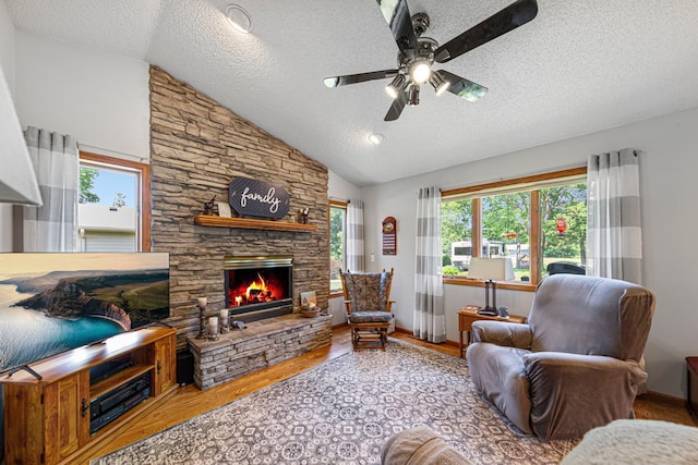 4820 Echo Ct, Faribault, MN 55021 - living room featuring a textured ceiling, a ceiling fan, wood finished floors, vaulted ceiling, and a fireplace