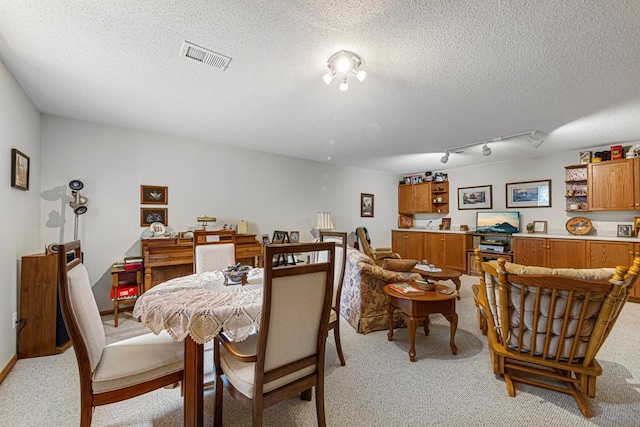 4820 Echo Ct, Faribault, MN 55021 - dining space with light carpet, a textured ceiling, and rail lighting