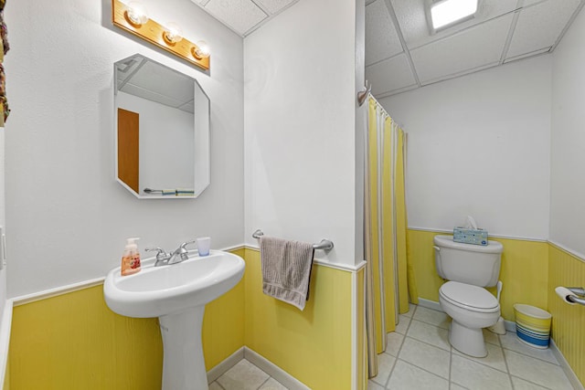 4820 Echo Ct, Faribault, MN 55021 - full bathroom featuring a drop ceiling, tile patterned floors, wainscoting, and a shower with shower curtain
