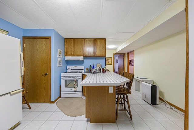 4820 Echo Ct, Faribault, MN 55021 - kitchen with white appliances, tile countertops, a kitchen breakfast bar, brown cabinetry, and light tile patterned floors