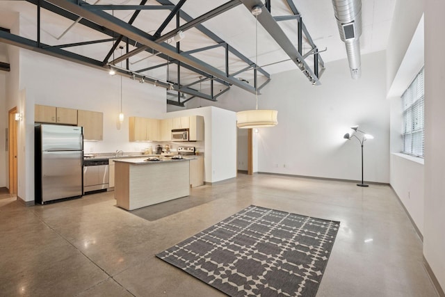 111 Franklin Ave Unit 215, Minneapolis, MN 55404 - kitchen featuring stainless steel appliances, a high ceiling, concrete floors, light brown cabinets, and a center island