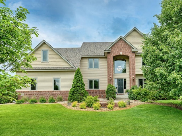 1847 140th Ln NE, Ham Lake, MN 55304 - view of front facade featuring a front yard, roof with shingles, and brick siding