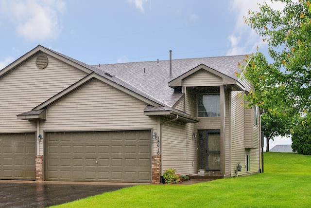 15616 84th St NE, Otsego, MN 55330 - view of front facade featuring a front lawn, a shingled roof, asphalt driveway, and a garage