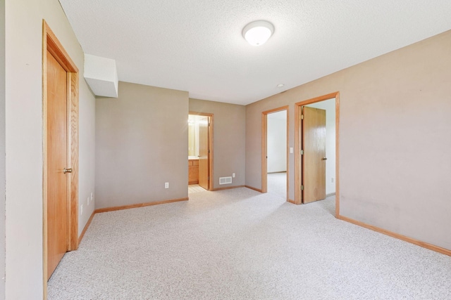 15616 84th St NE, Otsego, MN 55330 - unfurnished bedroom with light carpet, ensuite bathroom, and a textured ceiling