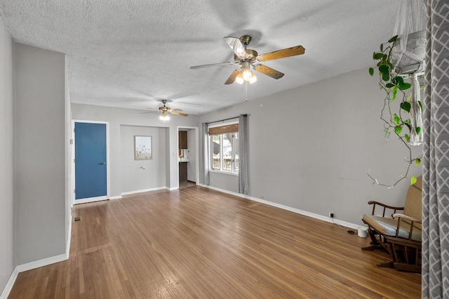 3521 26th St, Minneapolis, MN 55406 - unfurnished living room featuring wood finished floors, a ceiling fan, and a textured ceiling