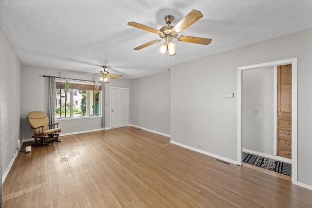 3521 26th St, Minneapolis, MN 55406 - empty room with light wood finished floors, a textured ceiling, and a ceiling fan