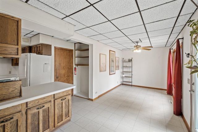 3521 26th St, Minneapolis, MN 55406 - kitchen featuring freestanding refrigerator, light countertops, a drop ceiling, ceiling fan, and brown cabinets