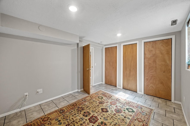 3521 26th St, Minneapolis, MN 55406 - unfurnished bedroom with two closets, a textured ceiling, tile patterned flooring, and recessed lighting