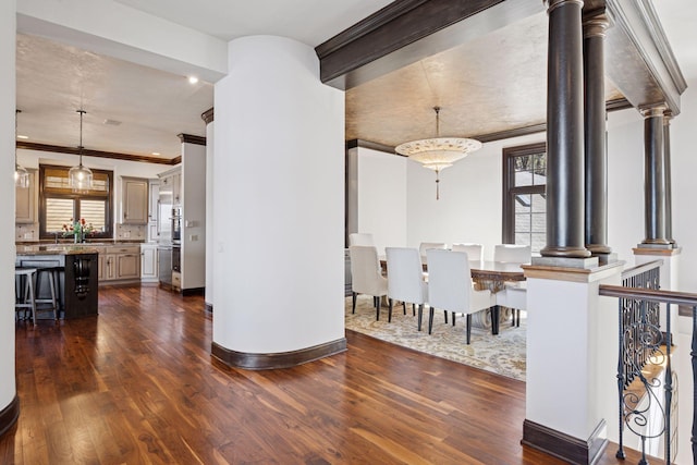 1709 1/2 Pulaski Rd, Buffalo, MN 55313 - dining space featuring ornamental molding, ornate columns, healthy amount of natural light, and dark wood-type flooring