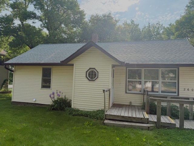 260 Maple St N, Balaton, MN 56115 - back of property with a lawn, a deck, roof with shingles, and a chimney