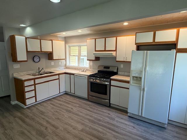 260 Maple St N, Balaton, MN 56115 - kitchen featuring white appliances, under cabinet range hood, white cabinetry, light countertops, and wood finished floors