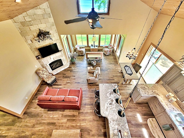 45207 281st Ln, Aitkin, MN 56431 - living area with wood finished floors, ceiling fan, a high ceiling, and a stone fireplace