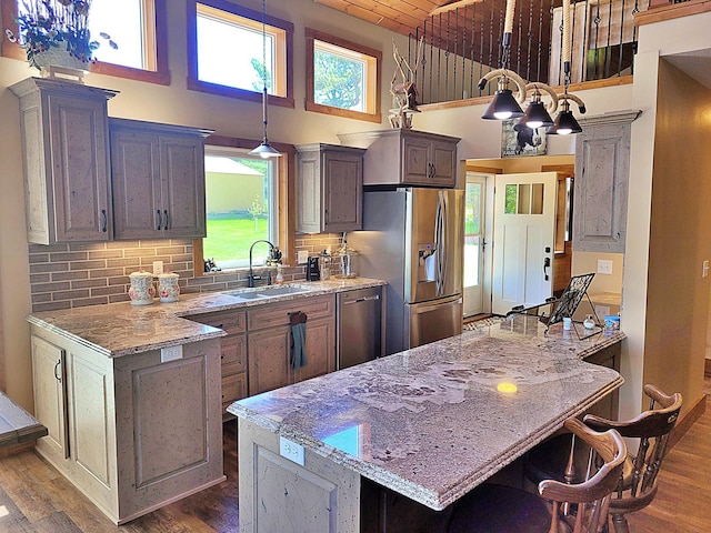 45207 281st Ln, Aitkin, MN 56431 - kitchen featuring stainless steel appliances, dark wood-style flooring, a towering ceiling, light stone counters, and a kitchen bar