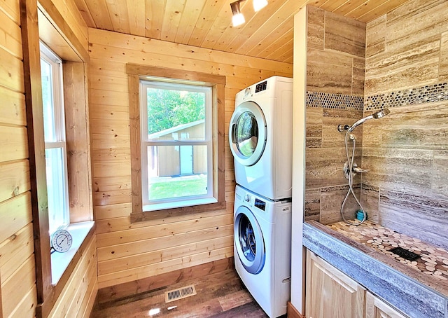 45207 281st Ln, Aitkin, MN 56431 - laundry room with stacked washer and clothes dryer, wooden walls, wooden ceiling, and dark wood finished floors