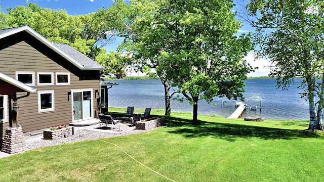 45207 281st Ln, Aitkin, MN 56431 - view of green lawn with a water view, a patio, and a fire pit