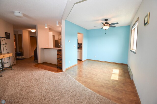 2515 25th St S Unit 303H, Fargo, ND 58103 - unfurnished living room with baseboard heating, ceiling fan, and light wood finished floors
