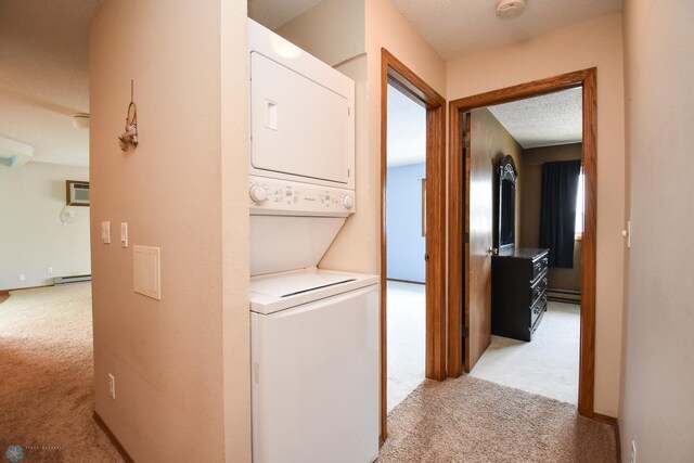 2515 25th St S Unit 303H, Fargo, ND 58103 - laundry area with light colored carpet, stacked washer and clothes dryer, a baseboard radiator, a wall mounted air conditioner, and baseboard heating