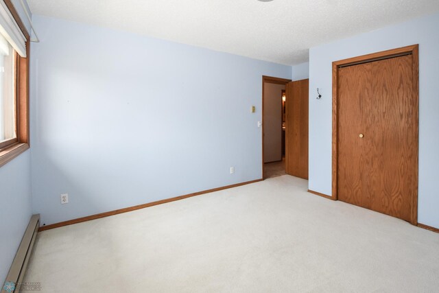 2515 25th St S Unit 303H, Fargo, ND 58103 - unfurnished bedroom with baseboard heating, carpet, and a closet