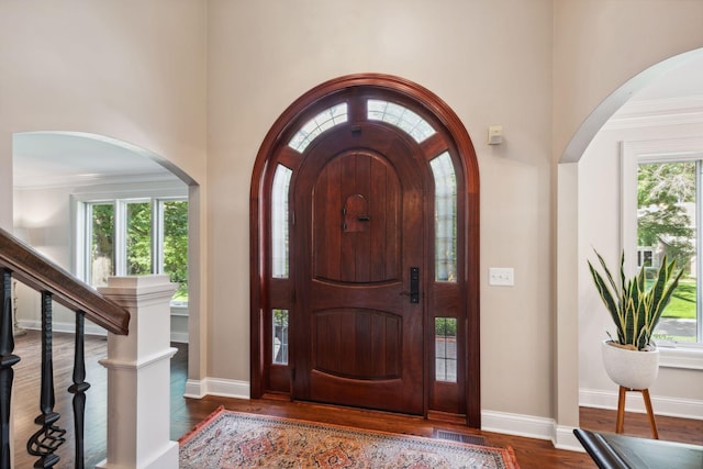 16209 Adeline Ln, Minnetonka, MN 55391 - entryway with arched walkways, dark wood-style flooring, a towering ceiling, and ornamental molding