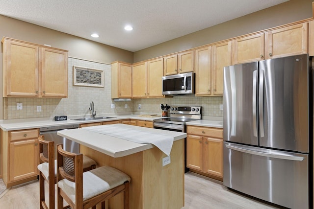 2014 Stahlke Way, Chaska, MN 55318 - kitchen featuring appliances with stainless steel finishes, light brown cabinetry, light wood finished floors, backsplash, and a textured ceiling