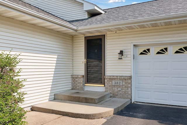 382 Tuttle Dr, Hastings, MN 55033 - doorway to property with a shingled roof, a garage, stone siding, and asphalt driveway