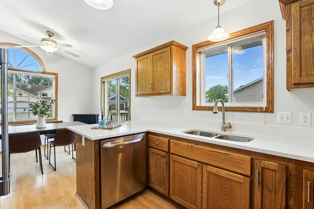 382 Tuttle Dr, Hastings, MN 55033 - kitchen with stainless steel dishwasher, lofted ceiling, brown cabinetry, ceiling fan, and light wood-style flooring