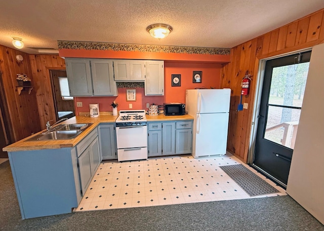 34243 County Highway 46, Park Rapids, MN 56470 - kitchen featuring white appliances, wood walls, a textured ceiling, a peninsula, and light flooring