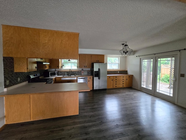 27891 Jerboa Ln, Cold Spring, MN 56320 - kitchen with appliances with stainless steel finishes, a peninsula, backsplash, dark wood-type flooring, and a textured ceiling