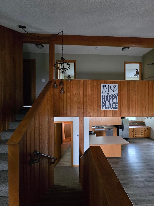 27891 Jerboa Ln, Cold Spring, MN 56320 - stairway featuring wood walls, a textured ceiling, and wood finished floors