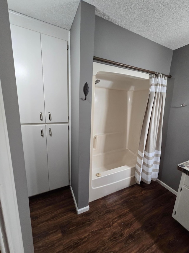 27891 Jerboa Ln, Cold Spring, MN 56320 - full bathroom featuring wood finished floors, a shower with shower curtain, a textured ceiling, and vanity
