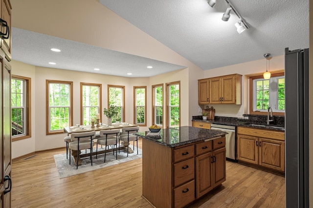 17121 Variolite St NW, Ramsey, MN 55303 - kitchen with stainless steel appliances, a textured ceiling, rail lighting, a center island, and light wood-style flooring