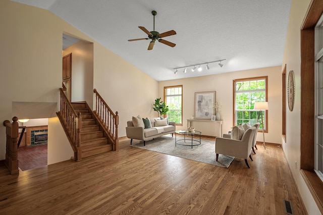 17121 Variolite St NW, Ramsey, MN 55303 - living room featuring wood finished floors, a ceiling fan, stairway, a tile fireplace, and vaulted ceiling