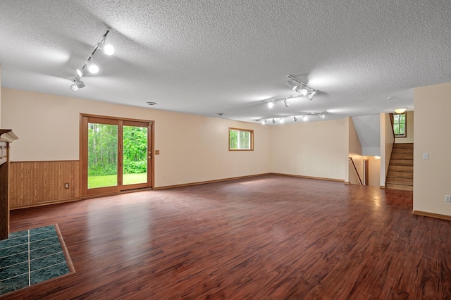 17121 Variolite St NW, Ramsey, MN 55303 - empty room with rail lighting, a textured ceiling, wood finished floors, a wainscoted wall, and stairway