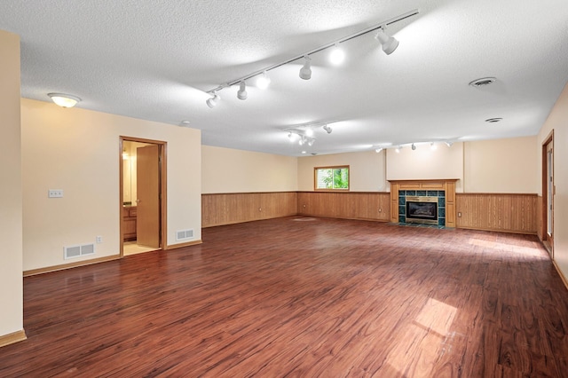 17121 Variolite St NW, Ramsey, MN 55303 - unfurnished living room featuring track lighting, wainscoting, wood finished floors, wooden walls, and a tile fireplace