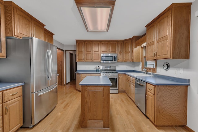 808 17th St SW, Willmar, MN 56201 - kitchen featuring stainless steel appliances, light wood-style flooring, a center island, and brown cabinetry