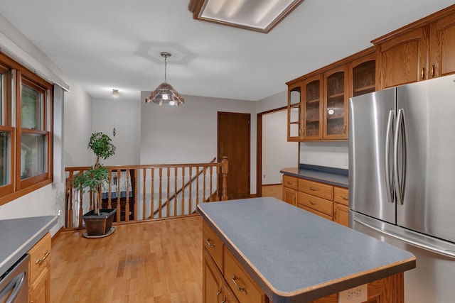 808 17th St SW, Willmar, MN 56201 - kitchen with stainless steel appliances, brown cabinetry, light wood-type flooring, and glass insert cabinets