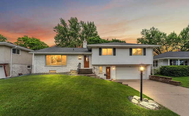 354 Edith Dr W, Saint Paul, MN 55118 - tri-level home featuring a garage, driveway, brick siding, a front yard, and a chimney