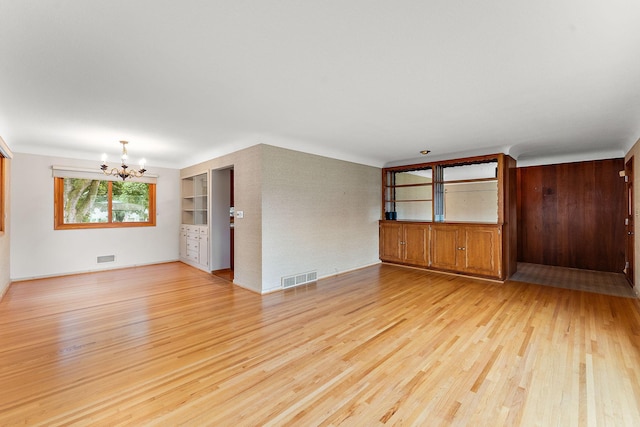 354 Edith Dr W, Saint Paul, MN 55118 - unfurnished living room featuring a chandelier and light wood-style flooring