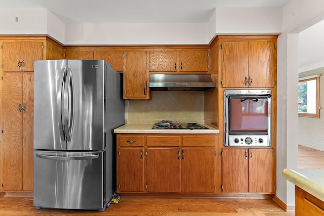 354 Edith Dr W, Saint Paul, MN 55118 - kitchen with freestanding refrigerator, under cabinet range hood, oven, light wood-style flooring, and light countertops
