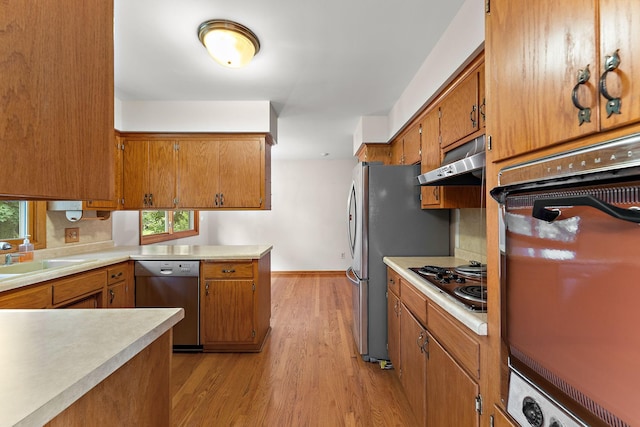 354 Edith Dr W, Saint Paul, MN 55118 - kitchen featuring appliances with stainless steel finishes, under cabinet range hood, light wood-type flooring, brown cabinets, and light countertops