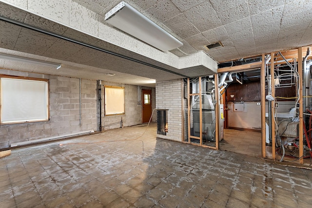 354 Edith Dr W, Saint Paul, MN 55118 - unfinished basement featuring concrete block wall, heating unit, a fireplace, and a baseboard radiator
