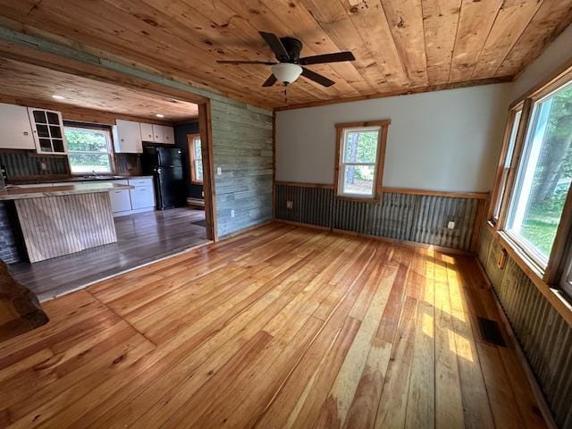 4623 Salo Rd, Waasa Twp, MN 55732 - unfurnished living room with hardwood / wood-style floors, wooden ceiling, a wainscoted wall, wooden walls, and healthy amount of natural light