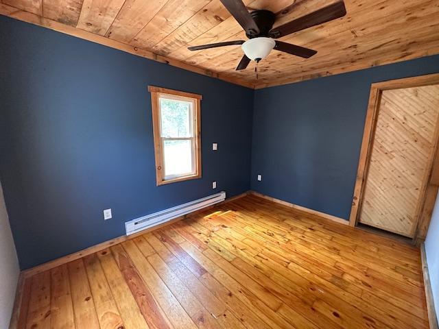 4623 Salo Rd, Waasa Twp, MN 55732 - unfurnished bedroom featuring a baseboard radiator, wooden ceiling, hardwood / wood-style floors, and ceiling fan