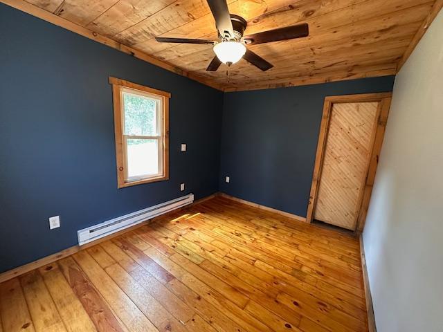 4623 Salo Rd, Waasa Twp, MN 55732 - empty room with a baseboard radiator, wooden ceiling, a ceiling fan, and hardwood / wood-style floors