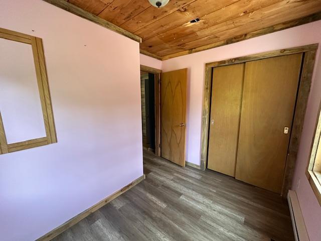4623 Salo Rd, Waasa Twp, MN 55732 - unfurnished bedroom with wooden ceiling, a baseboard radiator, wood finished floors, and a closet