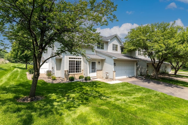 8741 Quarry Ridge Ln Unit H, Woodbury, MN 55125 - view of front of home with asphalt driveway, an attached garage, roof with shingles, a front yard, and brick siding