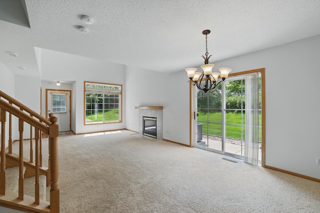8741 Quarry Ridge Ln Unit H, Woodbury, MN 55125 - unfurnished living room featuring carpet, a chandelier, healthy amount of natural light, and a textured ceiling